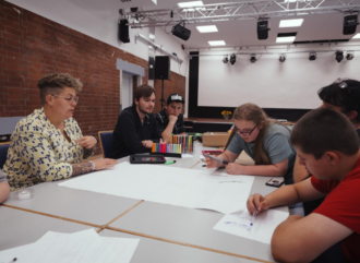 pädagogische Fachkraft mit Jugendlichen bei einem Workshop