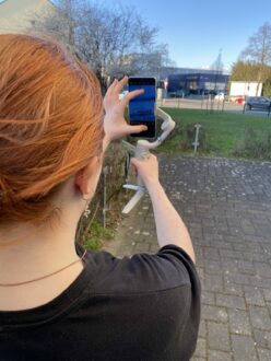 Eine Jugendliche filmt eine Szene mit einem Smartphone